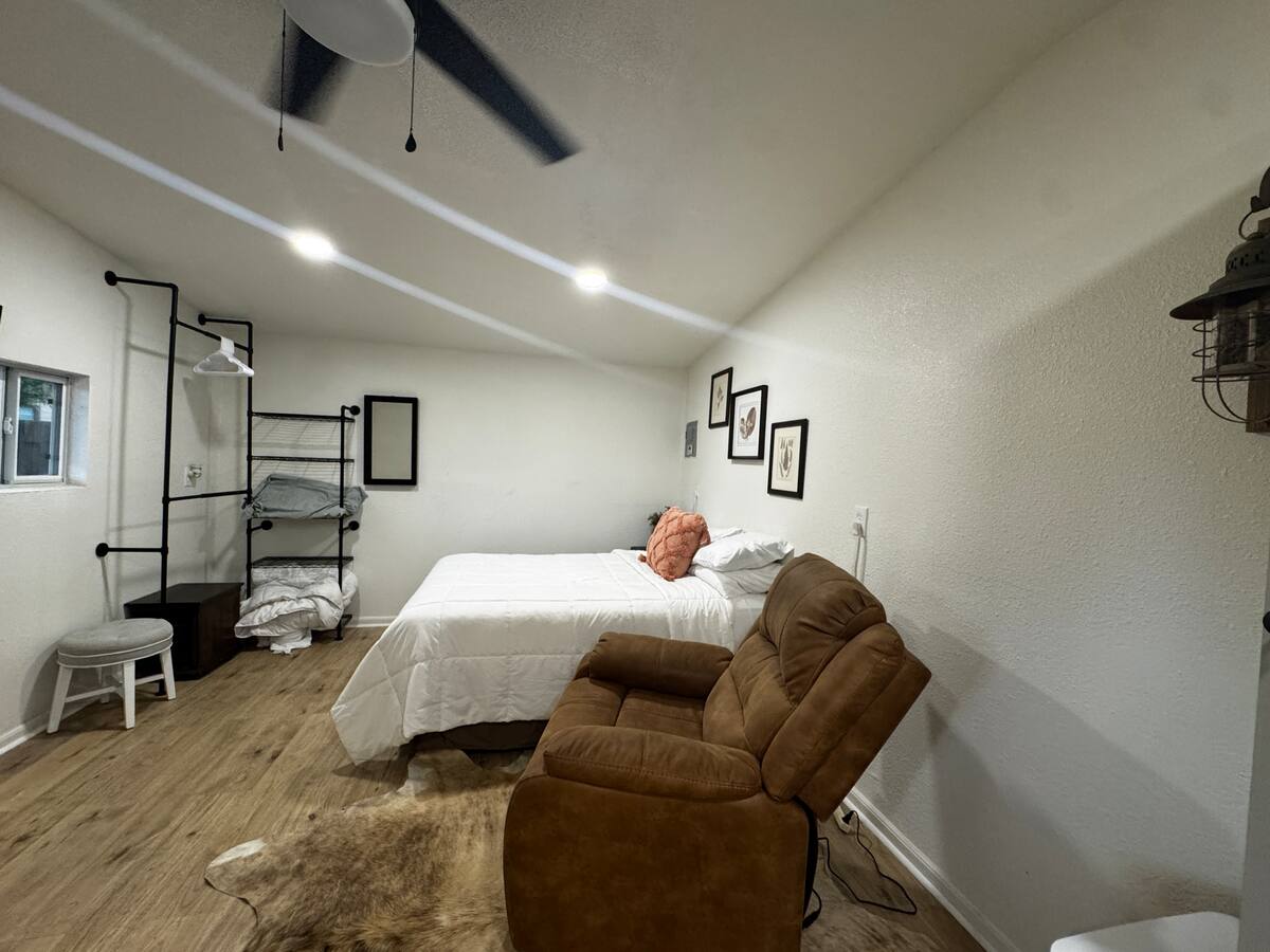 Interior sleeping area with queen bed and recliner